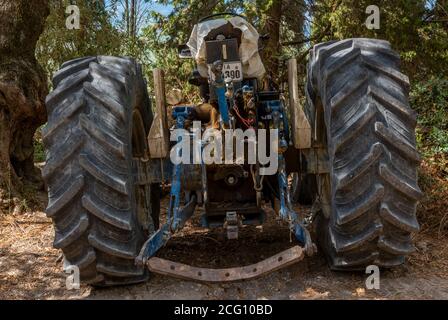 Ein alter alter rostiger Traktor am Straßenrand in einem griechischer Bauernhof auf der griechischen Insel zakynthos in griechenland Stockfoto