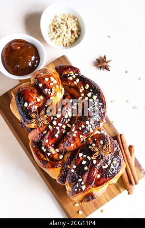 Babka oder Brioche Brot mit Aprikosenmarmelade und Nüssen. Hausgemachtes Gebäck zum Frühstück. Konkreter Hintergrund. Stockfoto