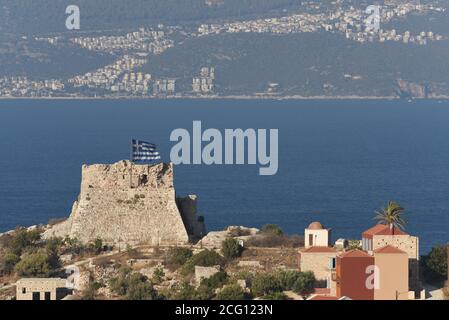 *** STRENG KEINE VERKÄUFE AN FRANZÖSISCHE MEDIEN ODER VERLAGE - RECHTE VORBEHALTEN ***08. September 2020 - Kastellorizo, Griechenland: Ein altes Schloss mit griechischer Flagge auf der Insel Kastellorizo, mit der Küste der Türkei und der türkischen Stadt Kas weit im Hintergrund sichtbar. Die Spannungen zwischen Griechenland und der Türkei eskalierten über diese 12 Quadratkilometer große Insel, die vor der türkischen Küste liegt und der entfernteste griechische Vorposten im östlichen Mittelmeer ist. Die kleine Insel ist für die Energieansprüche beider Länder im östlichen Mittelmeer von entscheidender Bedeutung. Stockfoto