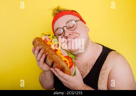 Fett lustige Mann umarmt einen riesigen Burger Stockfoto