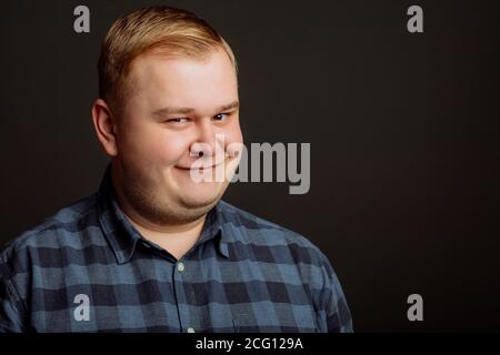 Portrait von lächelnden fetter Mann auf schwarzem Hintergrund Stockfoto