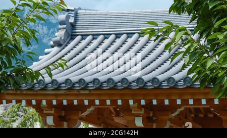 Klassisches geschwungenes graues Dach des Tores zum japanischen Zen-Garten. Stockfoto