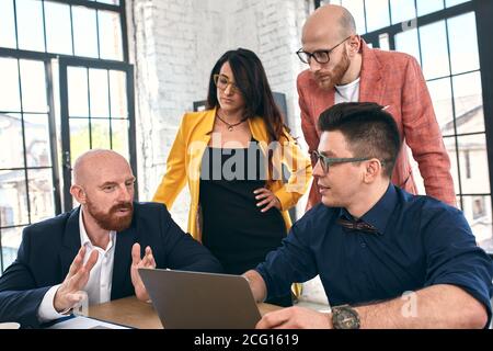 Geschossen von einer Gruppe junger Geschäftsleute in einer Sitzung. Vielfältige Gruppe von jungen Designern lächelnd während einer Besprechung im Büro. Stockfoto