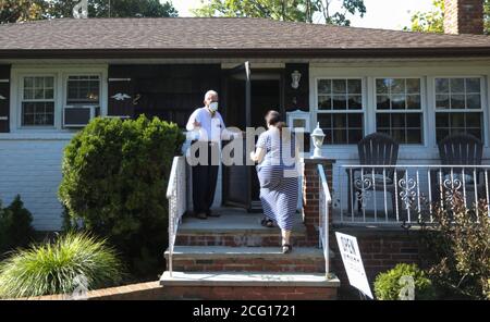 New York, USA. September 2020. Hemant Shah (L), ein Makler mit Laffey Real Estate auf Long Island, begrüßt einen potenziellen Käufer außerhalb eines Hauses zum Verkauf in New Hyde Park, Nassau County, New York, die Vereinigten Staaten, am 6. September 2020. Hauskäufer, die um gemütliche Hinterhöfe und mehr Büroflächen wetteifern, veranstalten Kriege in den Vororten um New York City inmitten der Ausbreitung der COVID-19-Pandemie. Quelle: Wang Ying/Xinhua/Alamy Live News Stockfoto