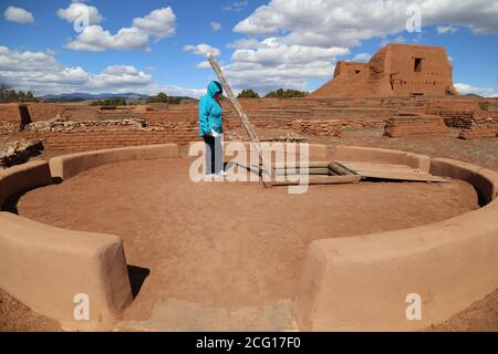 Unterirdische zeremonielle Kivas wurden für religiöse Aktivitäten verwendet. Ein Tourist blickt auf eine Kiva am Pueblo und Mission Ruins Trail bei Pecos Nati Stockfoto