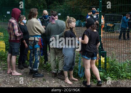 Denham, Großbritannien. September 2020. Ein Metropolitan Police Officer spricht mit HS2 Rebellion Aktivisten aus einem Gelände, das als Teil der Arbeiten an der HS2 Hochgeschwindigkeitsstrecke im Denham Country Park verwendet wurde, um Bäume zu Fällen. Anti-HS2-Aktivisten versuchen weiterhin, die Arbeiten an dem umstrittenen £106 Mrd. Projekt zu verhindern oder zu verzögern, für das die Bauphase am 4. September aus einer Reihe von Schutzlagern entlang der Strecke zwischen London und Birmingham angekündigt wurde. Kredit: Mark Kerrison/Alamy Live Nachrichten Stockfoto