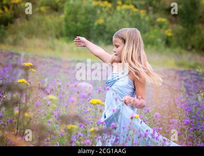 Junge Blonde Mädchen in einem Feld von Blumen Stockfoto