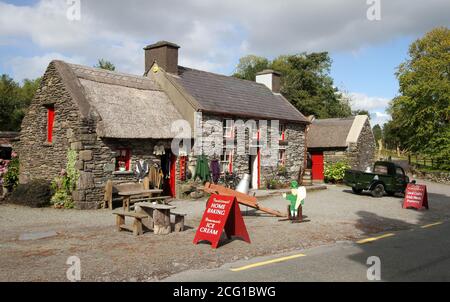 Traditionelle Steinhütte Bauernhof am Straßenrand und Besucherzentrum mit Handwerksladen in Irland in Molly Gallivan's Kenmare County Kerry an sonnigen Herbsttag. Stockfoto