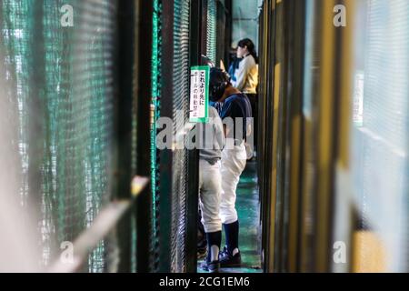 Japanische Menschen warten in der Schlange auf einen Schlagkäfig Stockfoto