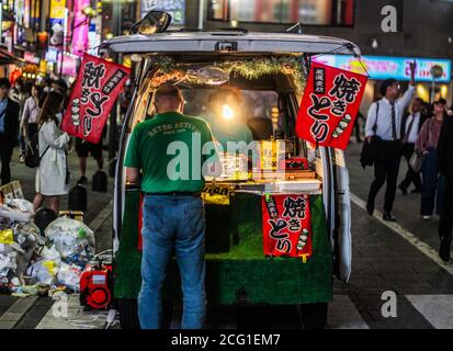 Mann, der Yakitori aus seinem Van in Shinjuku, Tokio, kocht Stockfoto