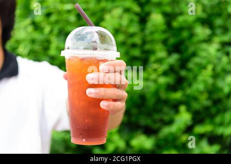 Der Mann hält Eistee für Sie Stockfoto