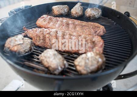 Schweineribs gebacken zu einem knackigen auf einem rauchigen Grill Stockfoto