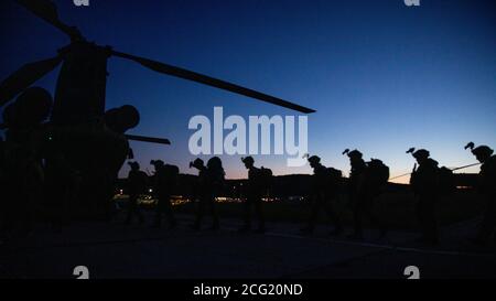 Soldaten der litauischen Nationalen Verteidigungsfreiwilligekraft (KASP) und der Spezialeinheiten der US-Armee werden während der Sabre Junction 20 in Hohenfels, Deutschland, im August auf einen CH-47 Chinook Hubschrauber geladen. 6, 2020. Sabre Junction 20 ist eine Force-on-Force-Übung mit 3,500 multinationalen Teilnehmern und über 140 multinationalen SOF aus Moldawien, Albanien, den USA, mit Mitgliedern des litauischen KASP, um die Integration zu verbessern und ihre Kampffähigkeiten insgesamt zu verbessern. (USA Armee Foto von Sgt. Patrik Orcutt) Stockfoto