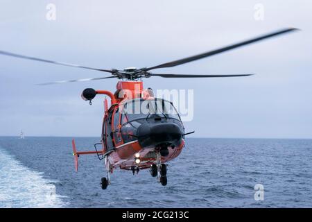 LT Katy Caraway landet den USGC MH-6567 Hubschrauber auf dem Flugdeck des Royal Danish Navy Vessel HDMS KNUD RASMUSSEN USCGC CAMPBELL wagte sich mit der HDMS KNUD RASMUSSEN in die Disko Bay zu gemeinsamen Helikoptertrainingsübungen. Disko Bay ist bekannt für seine starke Konzentration an großen Eisbergen, die vor dem Jacobshavn-Gletscher abkalben. Der Jacoshavn-Gletscher ist der Hauptfaktor für Eisberge in Baffin Bay und der Labradorsee. CAMPBELL navigierte sicher die schwere Konzentration von schwimmenden Eis, Eisberge von der Größe professioneller Sportstadien und startete ihr OTH-Cutter-Boot zum Training. Stockfoto