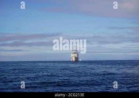 USCGC CAMPBELL wagte sich mit der HDMS KNUD RASMUSSEN in die Disko Bay für gemeinsame Helikoptertrainingsübungen. Disko Bay ist bekannt für seine starke Konzentration an großen Eisbergen, die vor dem Jacobshavn-Gletscher abkalben. Der Jacoshavn-Gletscher ist der Hauptfaktor für Eisberge in Baffin Bay und der Labradorsee. CAMPBELL navigierte sicher die schwere Konzentration von schwimmenden Eis, Eisberge von der Größe professioneller Sportstadien und startete ihr OTH-Cutter-Boot zum Training. CAMPBELL startete auch ihren MH-65 Hubschrauber, um Hebezeug, Rettungskorb und Landungen/Starts vom KNUD RASMUSSEN durchzuführen. Stockfoto