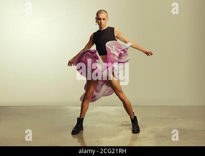 Geschlecht Flüssigkeit junger Mann im Crop top und Rock tanzen im Studio. Gay Mann tanzen im flowy Rock Stockfoto