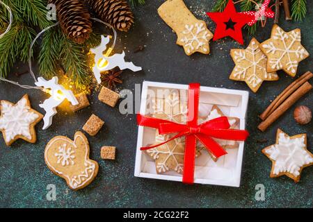 Weihnachtsbacken. Hausgemachte Lebkuchenkekse in einer Geschenkbox auf Stein- oder Schieferhintergrund. Draufsicht flach lagen Hintergrund. Stockfoto