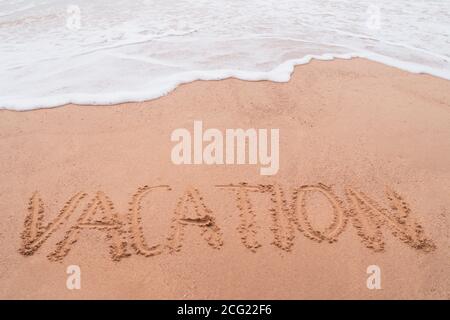 Urlaub Wort Hand gezeichnet auf Sand Sommer Strand Hintergrund. Stockfoto