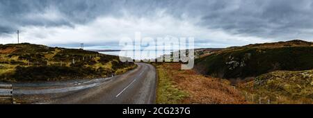 Straße zu einem kleinen Dorf am See irgendwo in Highlands, Schottland Stockfoto