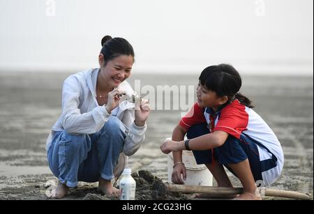 (200909) -- GUANGZHOU, 9. September 2020 (Xinhua) -- Lin Xiaolian (L) und ihre Studentin fangen Krabben an einem Strand der Beili Insel im Landkreis Xuwen, südchinesische Provinz Guangdong, 2. September 2020. Vor sechs Jahren kam Lin Xiaolian als freiwilliger Lehrer auf diese Insel, nachdem er an der Lingnan Normal University in Guangdong seinen Abschluss gemacht hatte. Und dann entschied sie sich, hier zu bleiben, um eine Lehrerin zu sein. Das abgelegene und von Armut heimgesuchte Inseldorf Beili sieht kaum Außenstehende. Es gibt keine Restaurants, Hotels oder Autos auf der Insel, die nur 7 Quadratkilometer umfasst. Die Beili Primary School hat über 300 Schüler, ist aber staf Stockfoto