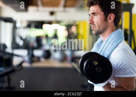Entschlossene junge Mann im Fitnessraum Stockfoto
