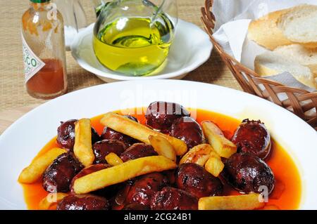 Mini Chorizo Würste und Kartoffelchip in Olivenöl Tapas, Costa del Sol, Provinz Malaga, Andalusien, Spanien, Europa. Stockfoto