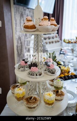 Hochzeitsbonbons, dekorierte Tische, Dekorationen und Cupcakes, leckeres Fleisch und Delikatessen Stockfoto