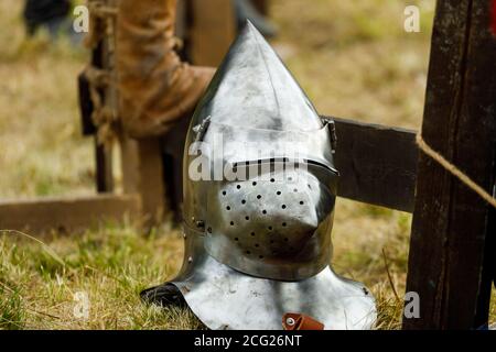 Metall mittelalterlichen Helm liegt auf dem Gras. Für ritterliche Duelle Stockfoto