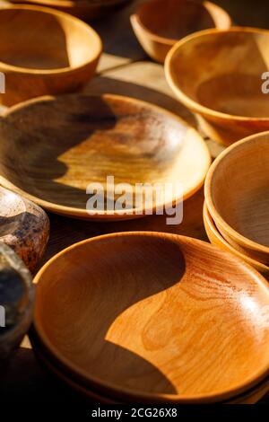 Braune Holzteller stehen in Reihen auf dem Tisch Stockfoto