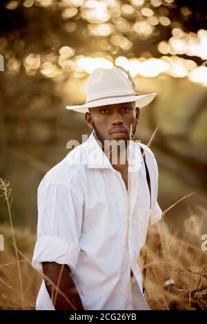 afrikanischer Gentleman im afrikanischen Busch mit Buschhut in Das Gras Stockfoto