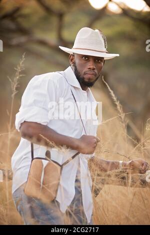 afrikanischer Gentleman im afrikanischen Busch mit Buschhut in Das Gras Stockfoto