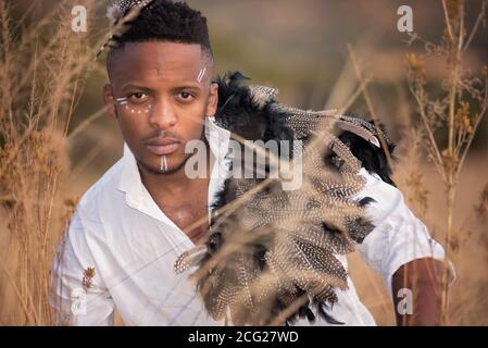 afrikanischer Gentleman im afrikanischen Busch mit Buschhut in Das Gras Stockfoto