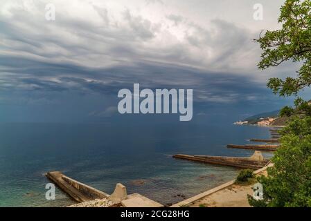 Sturmwolken verdicken sich vor dem Regen über dem Meer. Stockfoto