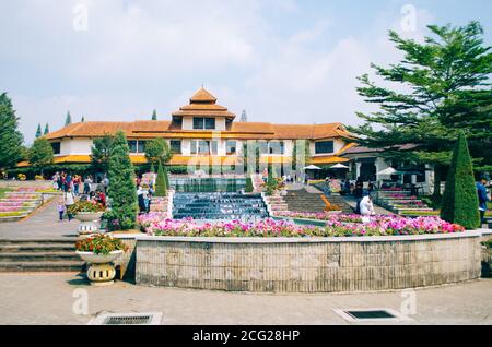 Bogor, Indonesien - BLICK auf den blühenden Park Taman Bunga Nusantara an einem bewölkten Nachmittag mit Blick auf den Eingang mit einem Springbrunnen. Stockfoto