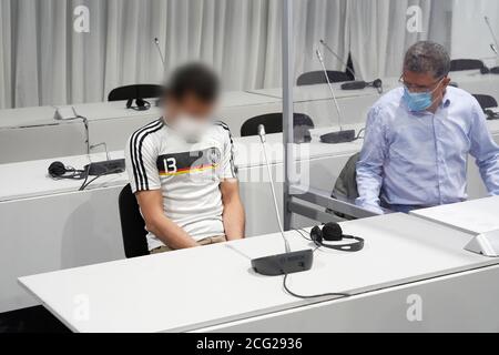 Limburg, Deutschland. September 2020. Der 33-jährige Beklagte (l) wartet im Gerichtssaal, der in einem Festzelt neben einem Dolmetscher provisorisch aufgestellt ist, auf den Beginn des Verfahrens. Er wird beschuldigt, im Oktober 2019 einen LKW in Limburg entführt und dann absichtlich in Autos gefahren zu haben, die vor einer Ampel geparkt wurden. 18 Menschen wurden verletzt. Kredit: Thomas Frey/dpa/POOL/dpa - ACHTUNG: Beklagter wurde aus rechtlichen Gründen pixeliert/dpa/Alamy Live News Stockfoto