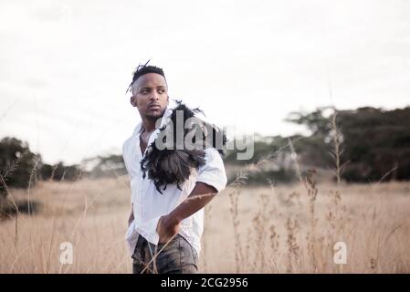 afrikanischer Gentleman im afrikanischen Busch mit Buschhut in Das Gras Stockfoto