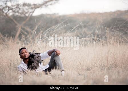 afrikanischer Gentleman im afrikanischen Busch mit Buschhut in Das Gras Stockfoto