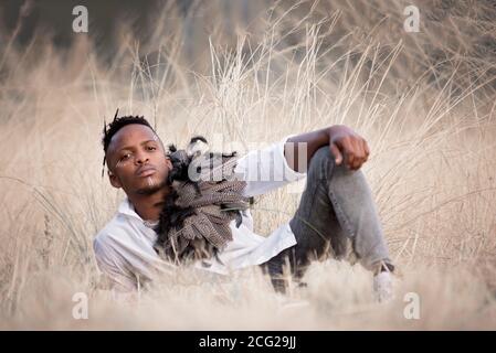 afrikanischer Gentleman im afrikanischen Busch mit Buschhut in Das Gras Stockfoto
