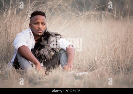 afrikanischer Gentleman im afrikanischen Busch mit Buschhut in Das Gras Stockfoto