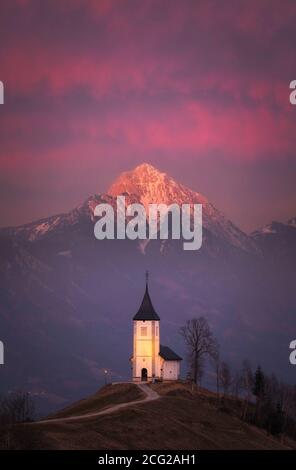 Kirche St. Primoz und Storzic Berg bei Sonnenuntergang, Jamnik, Slowenien Stockfoto