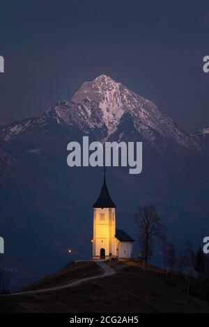 Kirche St. Primoz und Storzic Berg bei Sonnenuntergang, Jamnik, Slowenien Stockfoto