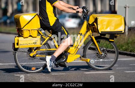 München, Deutschland. September 2020. Ein Postbote fährt mit dem Fahrrad eine Straße hinunter. Im Hinblick auf die nächste Verhandlungsrunde mit der Deutschen Post hat die Gewerkschaft Verdi Warnstreiks gefordert. Quelle: Sven Hoppe/dpa/Alamy Live News Stockfoto