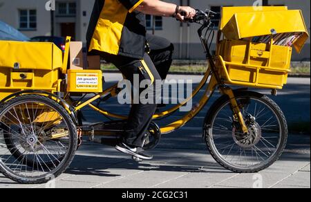 München, Deutschland. September 2020. Ein Postbote fährt mit dem Fahrrad eine Straße hinunter. Im Hinblick auf die nächste Verhandlungsrunde mit der Deutschen Post hat die Gewerkschaft Verdi Warnstreiks gefordert. Quelle: Sven Hoppe/dpa/Alamy Live News Stockfoto