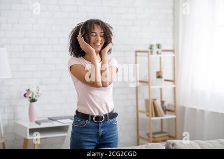 Genießen Sie Ihre Lieblingsmusik zur freien Zeit. Schöne afroamerikanische Mädchen in Kopfhörer Musik hören Stockfoto