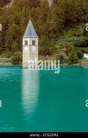 Der alte Glockenturm von Curon (Graun), der aus dem smaragdgrünen Wasser des Reschensee, Südtirol, Italien, hervorgeht Stockfoto