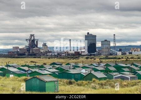 Fisherman's Association Hütten mit den Redcar Steelworks Beyond, South Gare, Redcar, North Yorkshire, Großbritannien Stockfoto