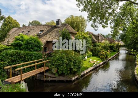 Giethoorn, Niederlande - 28. August 2020: Haus umgeben von Blumen am Kanal Stockfoto