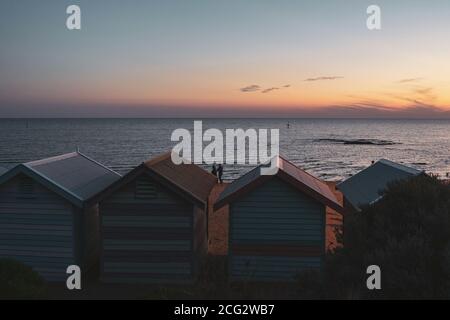 Beruhigender und friedlicher Strand mit Brighton Badekisten gegen Meer und Himmel während des Sonnenuntergangs in Esplanade, Brighton, Victoria, Australien Stockfoto