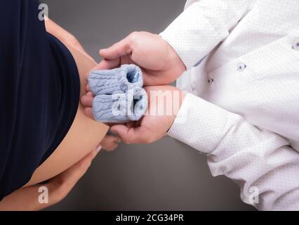 Cute Nahaufnahme der Herzform eines Paares Hände zusammen auf der schwangeren Frau Bauch. Selektiver Fokus. Stockfoto