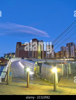 Blick auf den Weg und Radweg der Gateshead Millennium Bridge in Richtung Baltic Art Center in der Abenddämmerung. Stockfoto